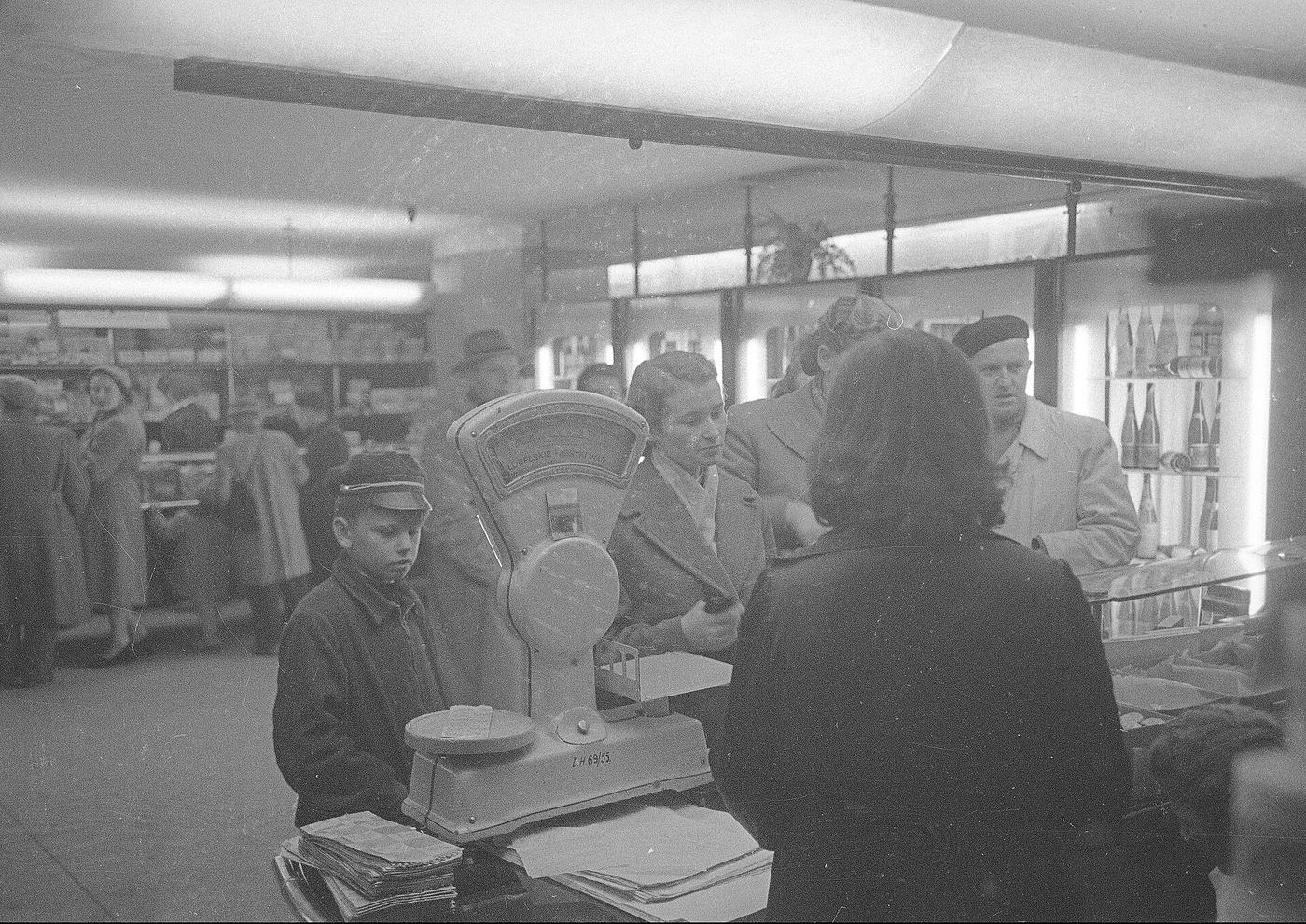Klienci przy ladzie sklepu w Warszawie w 1952 roku, na ladzie waga